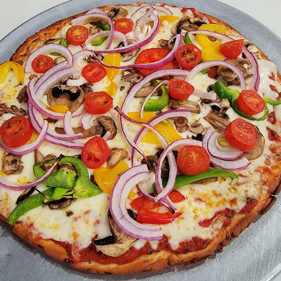 Grandi Italiani's vibrant pizza with red onions, bell peppers, mushrooms, and cherry tomatoes.